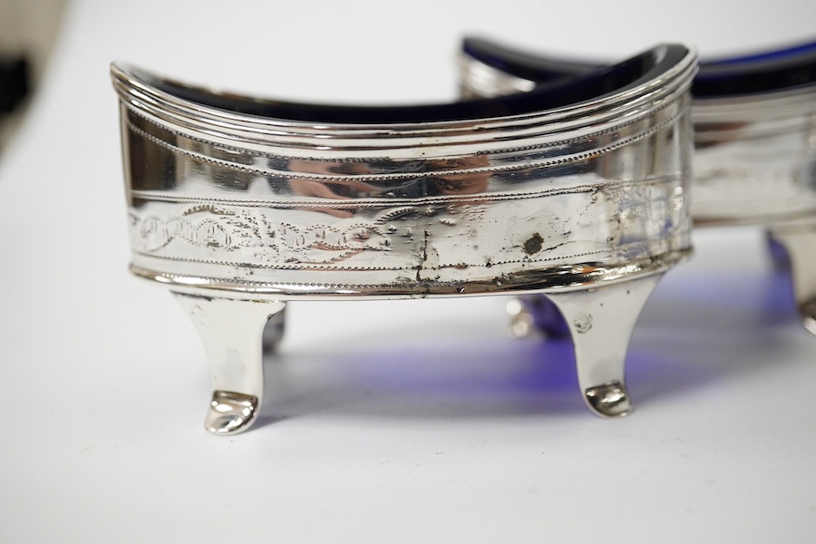 A set of four George III silver oval salts (a.f.) with blue glass liners, London, 1800, 83mm. Condition - poor